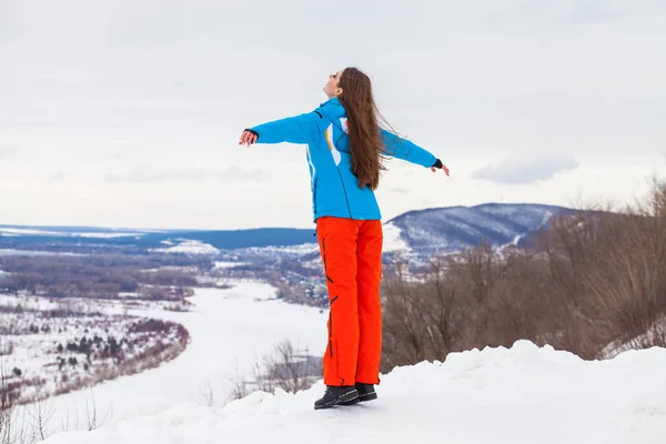 Jong brunette vrouw in een ski pak poseren op een heuveltop — Stockfoto