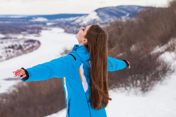 Jong brunette vrouw in een ski pak poseren op een heuveltop — Stockfoto