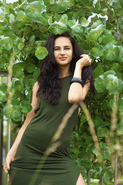 Porträtt av en ung vacker kvinna i grönt lövverk — Stockfoto