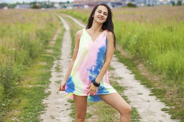 Młoda piękna kobieta w kolorowej tuniki stwarzające przeciwko ekspresyjne — Zdjęcie stockowe