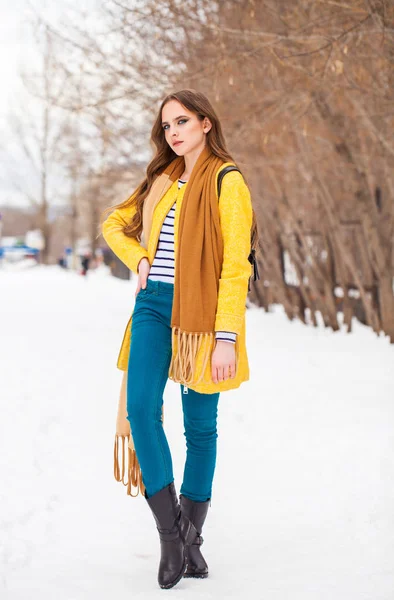 Young beautiful woman in yellow coat walking winter park — Stock Photo, Image