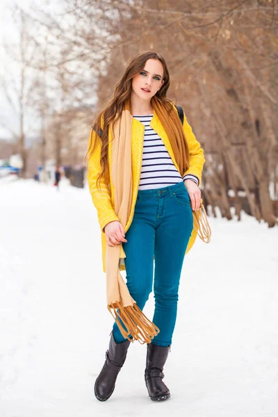 Молодая красивая женщина в желтом пальто ходьба зимний парк — стоковое фото