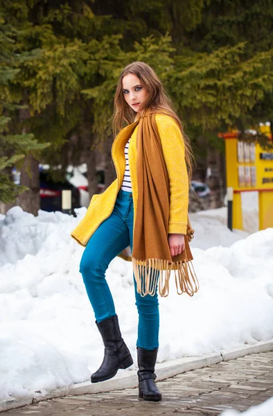 Young beautiful woman in yellow coat walking winter park — 스톡 사진
