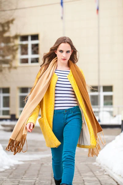 Young beautiful woman in yellow coat walking winter park — 스톡 사진