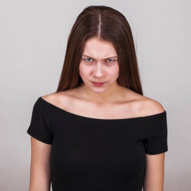 Gri arka planda izole edilmiş güzel esmer bir modelin yakın portresi.