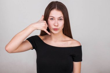 Gri arka planda izole edilmiş güzel esmer bir modelin yakın portresi.
