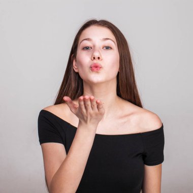 Gri arka planda izole edilmiş güzel esmer bir modelin yakın portresi.