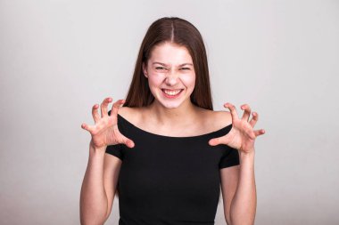 Bağırarak ve beyaz arka plan üzerinde bir hayvan gibi homurdanıyor güzel genç kadın.