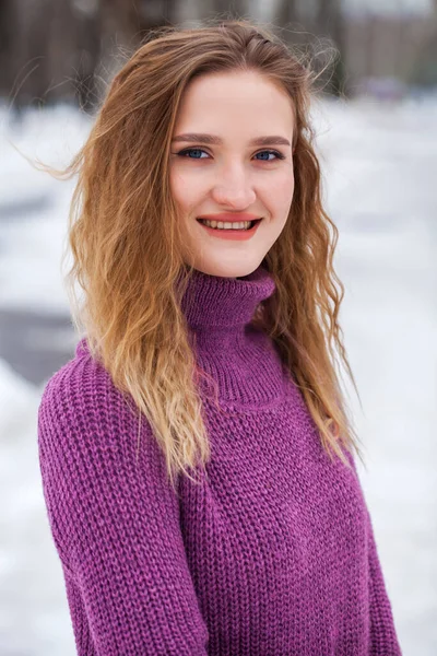 一名身穿毛衣的金发年轻女子在冬季公园摆姿势的画像 — 图库照片