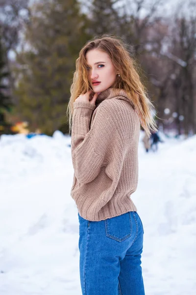 공원에서 포즈를 취하고 베이지 스웨터를 아름다운 금발의 여자의 — 스톡 사진