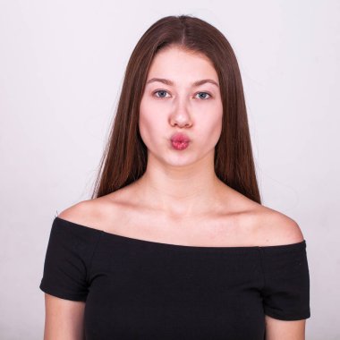 Gri arka planda izole edilmiş güzel esmer bir modelin yakın portresi.