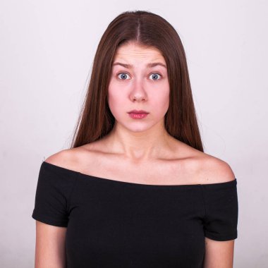 Gri arka planda izole edilmiş güzel esmer bir modelin yakın portresi.