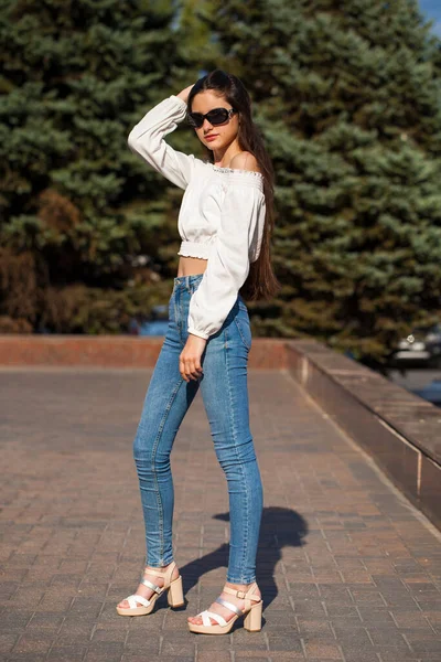 Chica Morena Bastante Elegante Vaqueros Azules Blusa Blanca Posando Fondo —  Fotos de Stock