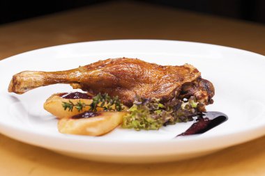 Ördek bacak beyaz bir tabak patates ile