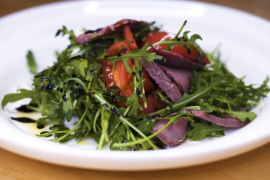 Restoran yemek - mermer sığır eti ve beyaz tabakta Roka Salatası