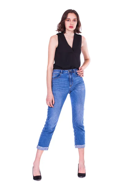 一个穿着蓝色牛仔裤的年轻漂亮的黑发模特的全身像 背景是白色的 — 图库照片