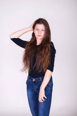 Gri arka planda izole edilmiş güzel esmer bir modelin yakın portresi.