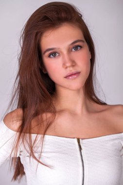 Gri arka planda izole edilmiş güzel esmer bir modelin yakın portresi.