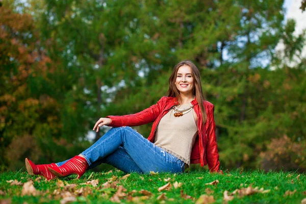 Młoda Piękna Kobieta Czerwonej Skórzanej Kurtce Niebieskich Dżinsach Siedząca Jesiennym — Zdjęcie stockowe