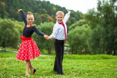Çocuklar dans ediyor. Takım elbiseli çift, yazın açık havada.