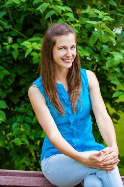 Taze ve temiz tenli, güzel, genç, mutlu esmer bir kadının açık hava yaz portresi.