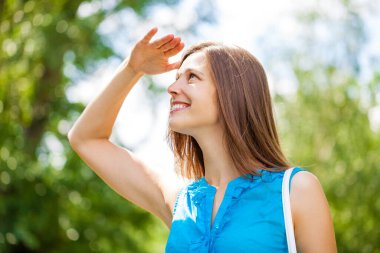 Taze ve temiz tenli, güzel, genç, mutlu esmer bir kadının açık hava yaz portresi.