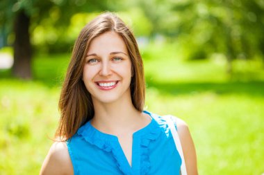 Taze ve temiz tenli, güzel, genç, mutlu esmer bir kadının açık hava yaz portresi.