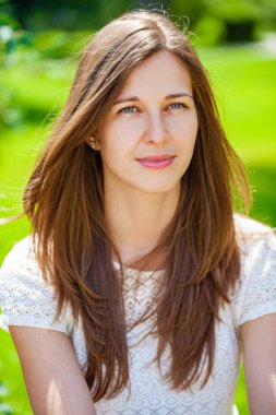 Taze ve temiz tenli, güzel, genç, mutlu esmer bir kadının açık hava yaz portresi.