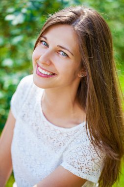 Taze ve temiz tenli, güzel, genç, mutlu esmer bir kadının açık hava yaz portresi.