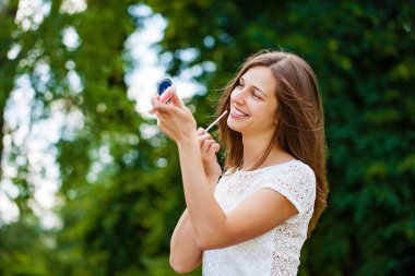 Ruj asistanı güzel esmer kadın. Kapalı yaz, açık havada.