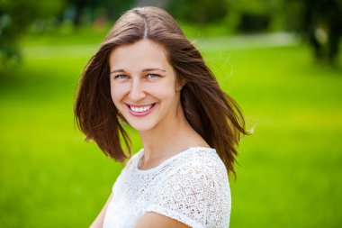 Taze ve temiz tenli, güzel, genç, mutlu esmer bir kadının açık hava yaz portresi.