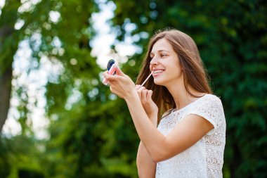 Ruj asistanı güzel esmer kadın. Kapalı yaz, açık havada.