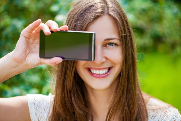 年轻美丽的黑发女人 显示你的智能手机屏幕 夏季公园户外 — 图库照片