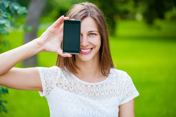 Jonge Mooie Brunette Vrouw Toont Smartphone Scherm Zomer Park Buitenshuis — Stockfoto