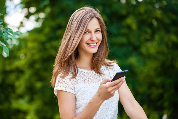 Mulher Jovem Mensagens Texto Telefone Inteligente Andando Parque Verão — Fotografia de Stock