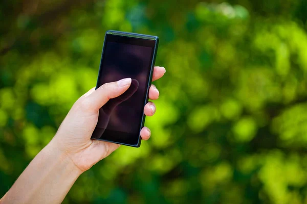 Vista Lateral Mano Una Mujer Sosteniendo Teléfono Inteligente Moderno Mientras —  Fotos de Stock