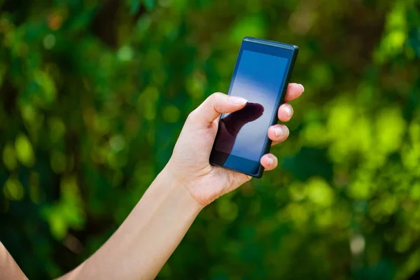 Vista Lateral Mano Una Mujer Sosteniendo Teléfono Inteligente Moderno Mientras —  Fotos de Stock