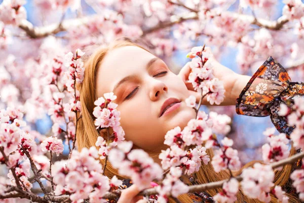 美丽的少女在樱桃树旁摆弄着粉红色的花朵 — 图库照片