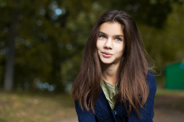 秋の公園の背景でポーズ幸せなブルネットの女の子 — ストック写真