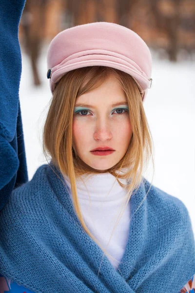 美しさを作る 若いです美しいですブロンド女の子で青コートとピンクキャップPosingで冬の公園 — ストック写真