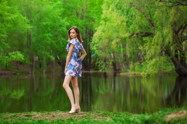 一个身穿蓝色衣服 在湖边摆姿势的年轻漂亮女子的全身像画像 — 图库照片