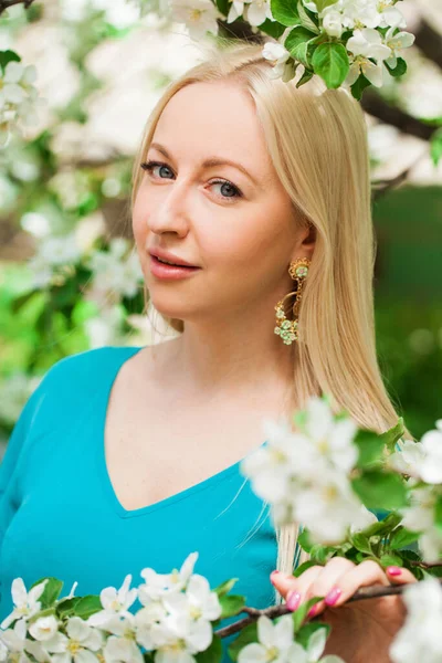 청록색 정원에서 꽃피는 사과나무의 배경에 포즈를 취하는 아름다운 여인의 — 스톡 사진