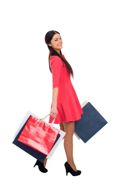 Młoda Piękna Brunetka Czerwonej Sukience Torbami Zakupy Odizolowana Białym Tle — Zdjęcie stockowe