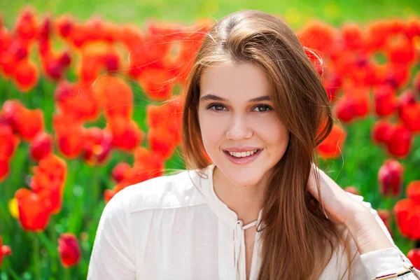 Portret Młodej Pięknej Dziewczyny Letniej Sukience Pozującej Trawniku Czerwonymi Tulipanami — Zdjęcie stockowe