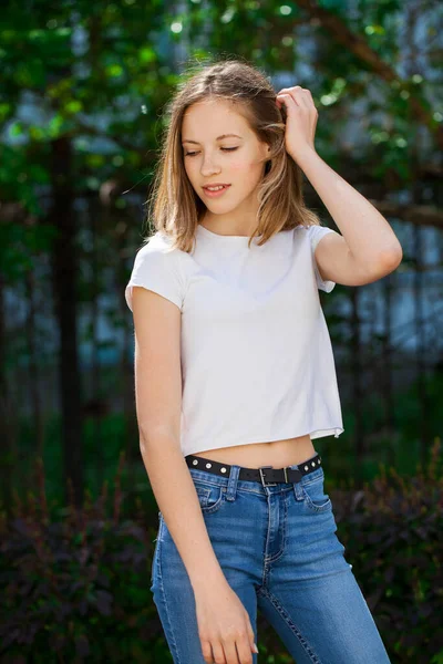 白いTシャツの若い美しいブロンドの女の子の肖像 夏の公園の屋外背景 — ストック写真