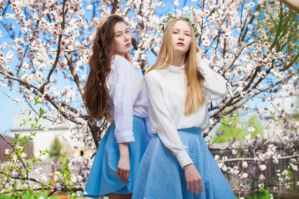 Dvě Šťastné Dívky Pózující Zahradě Poblíž Květu Třešeň Bílými Květy — Stock fotografie