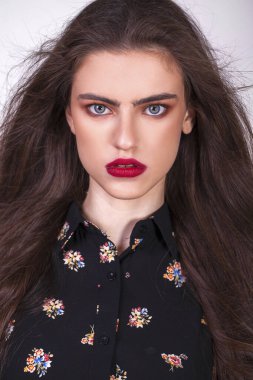 Gri arka planda izole edilmiş güzel esmer bir modelin yakın portresi.