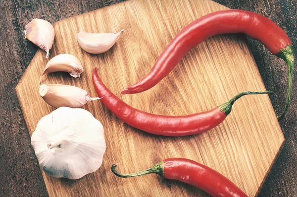 Knoflook en hete pepers op de houten bord — Stockfoto