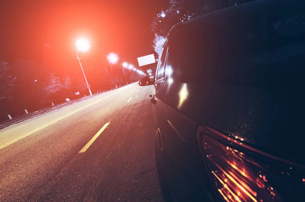 Черный автомобиль на ночной городской улице — стоковое фото
