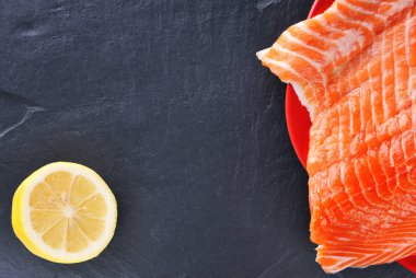 Yarım limon ile bir tabakta somon fileto